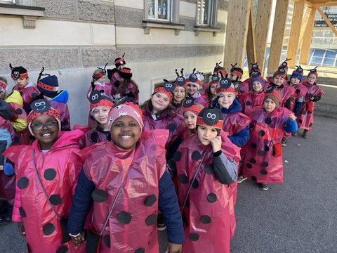 Kinder der Klassen 1a, 1b und 1c als Marienkäfer verkleidet unterwegs beim Faschingsumzug