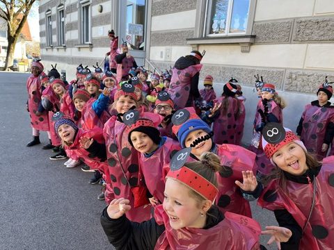 Kinder der Klassen 1a, 1b und 1c als Marienkäfer verkleidet unterwegs beim Faschingsumzug